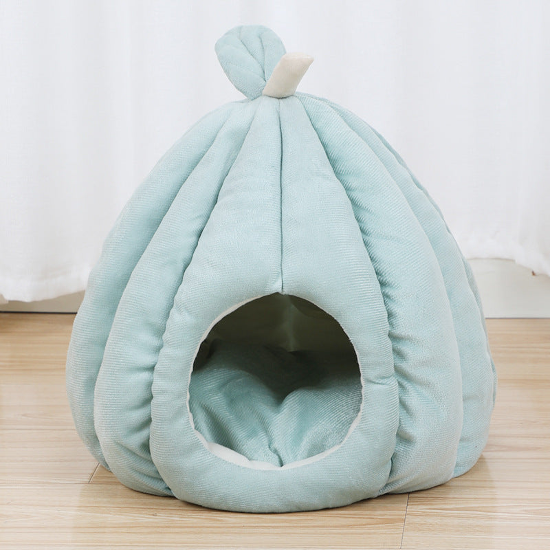 Light teal pumpkin cat bed on wooden floor